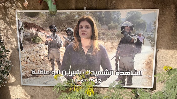 Ein großes Foto der Journalistn Shireen Abu Akleh (im Hintergrund sind Soldaten zu sehen), das am Straßenrand angebracht ist. © ARD Foto: Bettina Meier