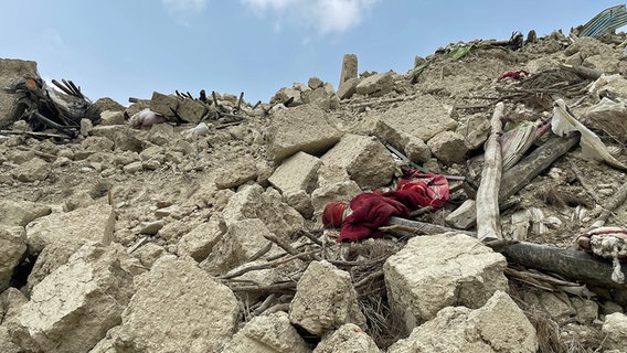 Aus Trümmern lugt Kleidung hervor. © ARD Foto: Peter Hornung