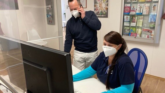 Ein Arzt und eine Fachangestellte mit FFP2-Maske in einer Arztpraxis. © NDR Foto: Birgit Augustin