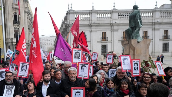 Gabriel Boric, Präsident von Chile, (Mitte l) und Menschen mit Bildern von Vermissten während einer Demonstration zum 50. Jahrestag des Militärputsches von General Pinochet vor dem Präsidentenpalast La Moneda. © picture alliance Foto: Esteban Felix