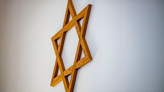 Ein Davidstern aus Holz hängt an der Wand einer Synagoge. © picture alliance Foto: David Inderlied