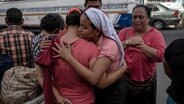 Mehrere Frauen nehmen sich weinend, trauernd in den Arm, an einer Straße. © ARD Foto: Carlos Barrera