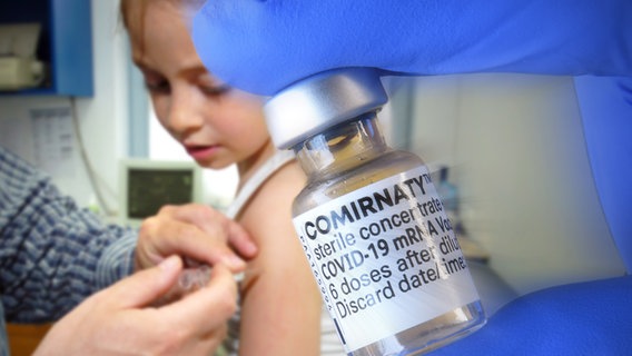 Ein Mädchen wird geimpft, im Vordergrund das Vakzin. © dpa picture alliance Foto: Frank Hoermann/Sven Simon