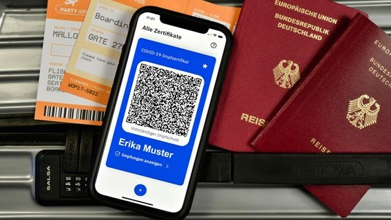 Bordkarten, ein digitaler Impfpass im Smartphone und Reisepässe liegen auf einem Koffer. © dpa picture alliance Foto: Michael Weber