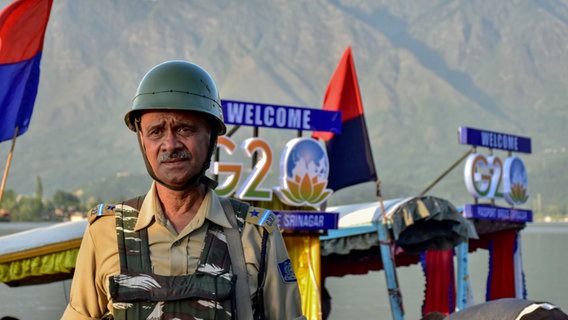 Ein paramilitärischer Soldat steht vor dem G20-Gipfel am Ufer des Dal-Sees. Im Vorfeld des G20-Gipfels wurden die Sicherheitsvorkehrungen im gesamten Kaschmirtal verstärkt. © picture alliance Foto: Saqib Majeed
