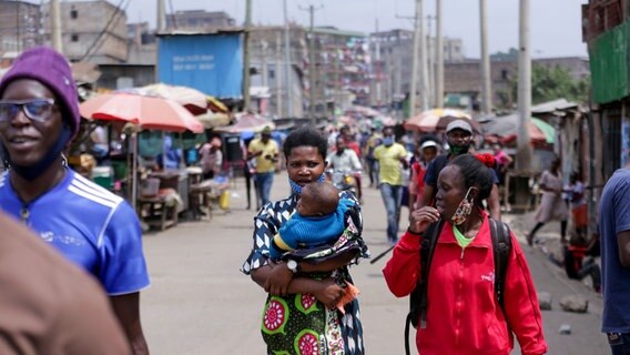 Zwei Frauen und ein Baby in einer belebten Straße von Nairobi. © dpa picture alliance Foto: Zuma Press Billy Mutai