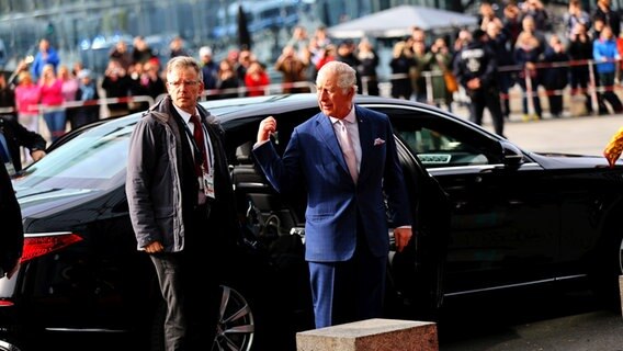 King Charles gestikulierend vor einer Limousine vor dem Berliner Hauptbahnhof. © picture alliance Foto: Simone Kuhlmey