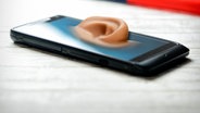 Ein Ohr ragt aus dem Display eines Smartphones (Montage). © dpa picture alliance Foto: Christian Ode