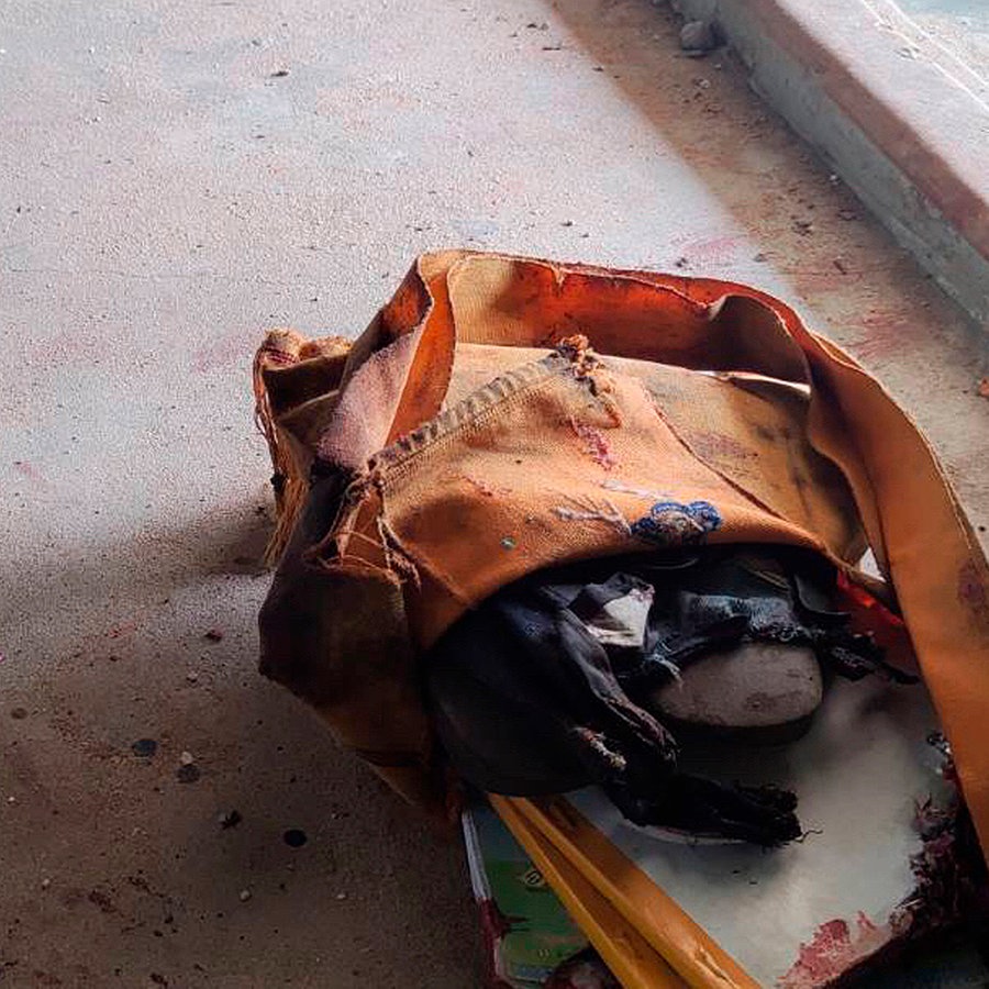 Blutverschmierte Schultasche mit Büchern auf dem Boden einer Schule, nach einem Luftangriff der Militäjunta. © picture alliance 