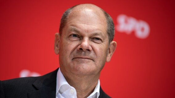 Olaf Scholz vor rotem Hintergrund mit SPD-Schriftzug. © dpa picture alliance Foto: Bernd von Jutrczenka