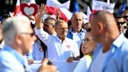 Donald Tusk (Mitte), Oppositionsführer von Polen, winkt, während er den "Marsch der Million Herzen" zur Unterstützung der Opposition gegen die regierende populistische Partei "Recht und Gerechtigkeit" anführt. © picture alliance Foto: Rafal Oleksiewicz