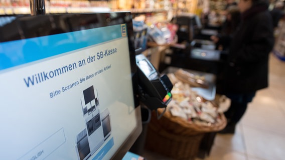 Der Monitor einer SB-Kasse mit "Herzlich Willkommen" in einem Supermarkt. © dpa picture alliance Foto: Swen Pförtner