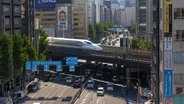 Ein Shinkansen (Zug) fährt durch die Hochhauslandschaft Tokios. © picture alliance Foto: Stanislav Kogiku