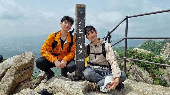 Min Ki und sein Bruder Min Gyu, Ingenieur und Autor, an einem Berggipfel. © Min Gyu Foto: privat