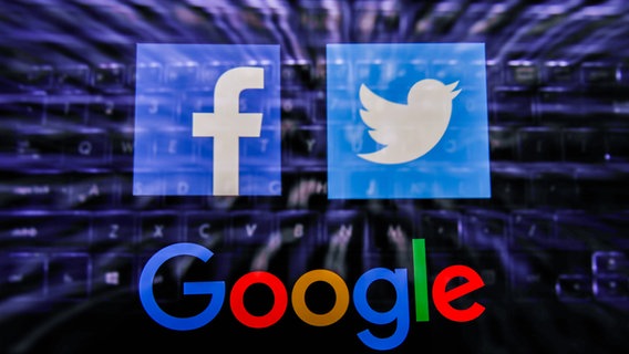 Die Icons von Facebook, Twitter und der Google-Schriftzug vor verschwommenem Tastatur-Hintergrund (Montage). © dpa picture alliance / NurPhoto Foto: Jakub Porzycki