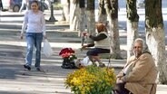 Zwei Straßenhändlerinnen verkaufen Blumen am Wegesrand © picture-alliance/dpa 