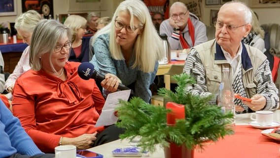 Eine Hörerin spricht einen Gruß ins Mikrofon von Moderatorin Birgit Langhammer. © NDR Foto: Cordula Kropke