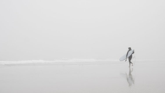 Einsamer Surfer am Strand. © Photocase Foto: Maccaroni