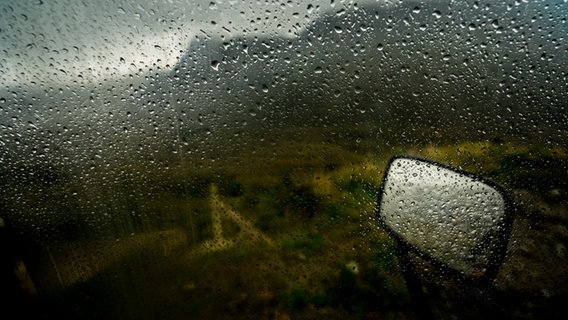 Blick aus einem Auto, dessen Scheibe voller Regentropfen ist. © Photocase Foto: 50Centimos