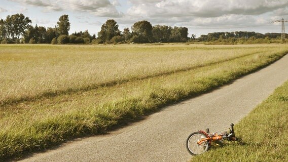 Ein Fahrrad liegt am Straßenrand. © Photocase Foto: suschaa