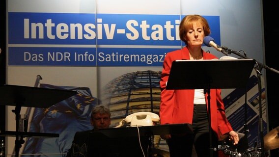 Antonia von Romatowski als Angie Merkel auf der Bühne der Burg in Seevetal am 28.11.2021. © NDR Foto: Jenny von Gagern