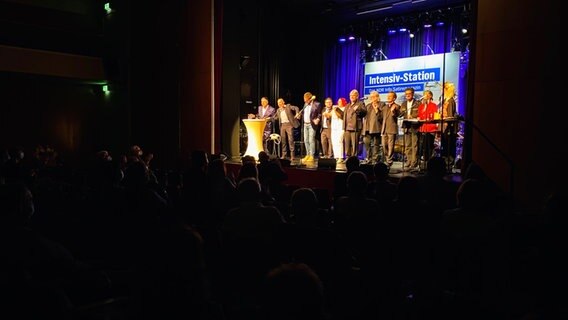 Viele Menschen auf der Bühne im Forum in Peine am 31.10.2021. © NDR Foto: Jenny von Gagern
