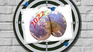 Eine Bildmontage zeigt die Weltkugel in Form eines menschlichen Hinterns und mit der Aufschrift 2022. © Zoonar / imageBROKER Foto: Mustafa Almir Mahmoud / scully
