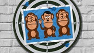 Das Bild zeigt 3 gezeichnete Affen, die nebeneinander sitzen. Der in der Mitte erinnert an Adolf Hitler, die beiden links und rechts von ihm halten sich die Augen zu. © NDR Foto: Jonas Storjohann