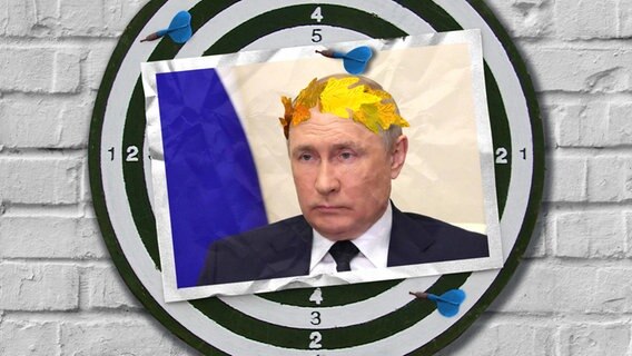 Eine Bildmontage zeigt eine Dartscheibe. Darauf ist eine Postkarte mit einer Fotomontage zu sehen. Sie zeigt Wladimir Putin mit einem golden Lorbeer-Kranz. © Imago / Zuma Wire; Imago / Rudof Gigler Foto: Imago / Zuma Wire; Imago / Rudof Gigler