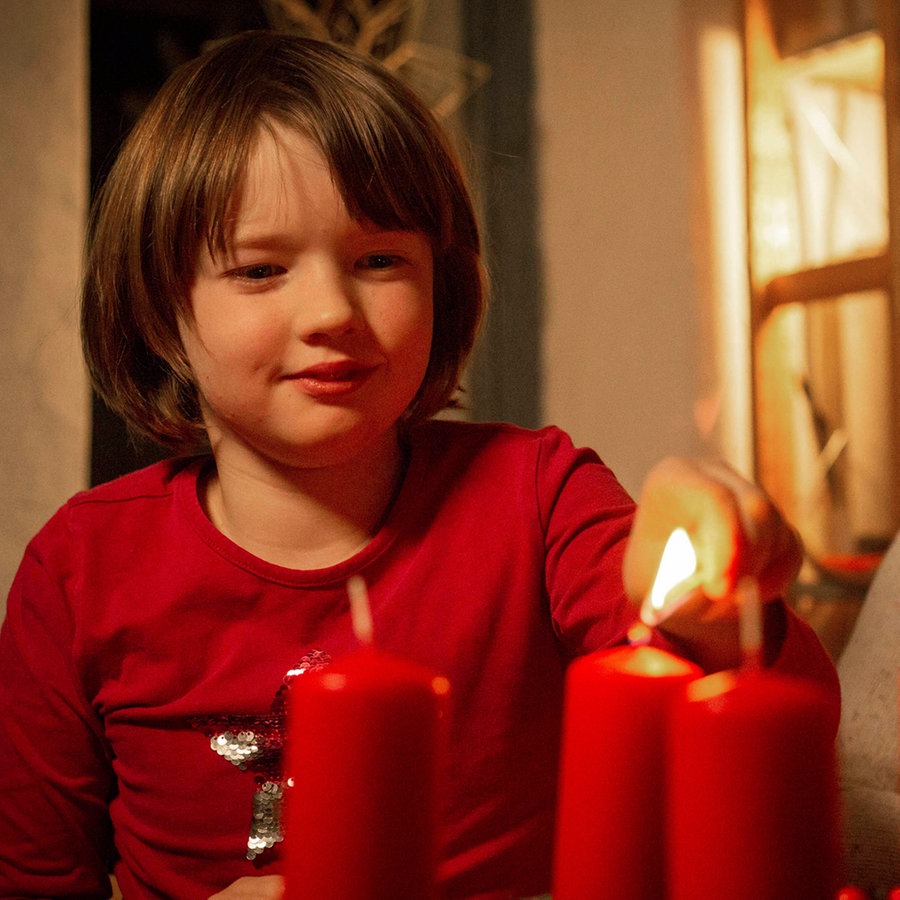 Zwei Kinder zünden einen Adventskranz an © IMAGO / epd 