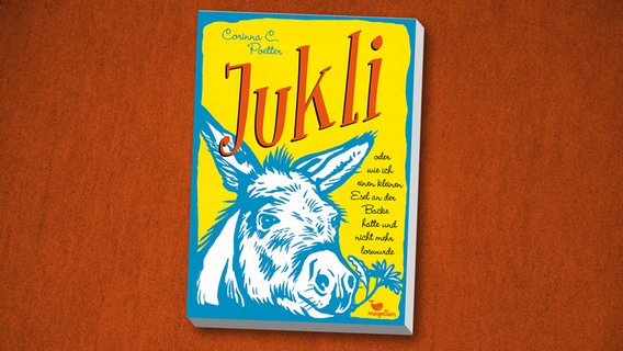 Cover des Kinderbuches "Jukli oder wie ich einen kleinen Esel an der Backe hatte und nicht mehr loswurde" von Corinna C. Poetter, erschienen im Verlag Magellan. Cover des Kinderbuches "Jukli oder wie ich einen kleinen Esel an der Backe hatte und nicht mehr loswurde" von Corinna C. Poetter, erschienen im Verlag Magellan. © Magellan Verlag