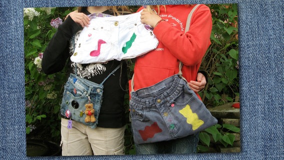 Zwei Kinder zeigen ihre selbstgenähten "Hosentaschen" in die Kamera.  Foto: Ulrike Rahn