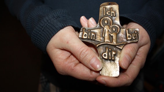 Ein Kreuz liegt in einer Hand. © NDR Mikado Foto: Fatma Sahin