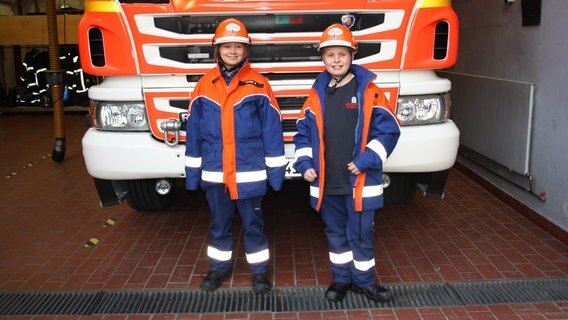 Zwei Kinder der Jugendfeuerwehr stehen vor einem Feuerwehrauto. © NDR Mikado Foto: Fatma Sahin