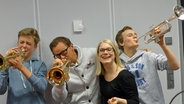 Die Studiogäste Luis und Oskar von der Junior-Bigband des Albert Schweitzer Gymnasiums Hamburg (links und rechts außen), der Trompeter Ingolf Burkhardt von der NDR Bigband und Moderatorin Jessica Schlage im Mikado-Studio. © NDR Foto: Aline König