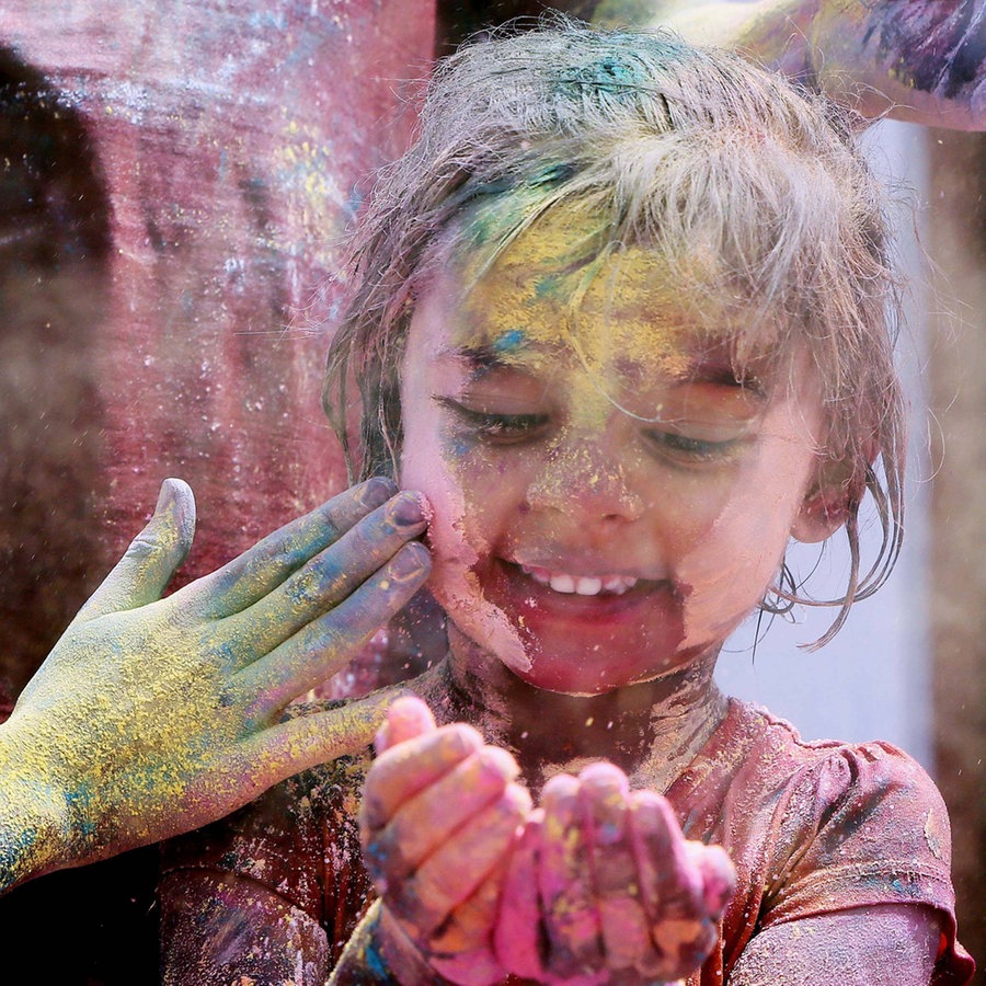 Ein Kind ist mit bunter Farbe angemalt © IMAGO / Xinhua 