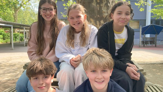 Fünf Kinder sitzen unter einem Baum und schauen in die Kamera Fünf Kinder sitzen unter einem Baum und schauen in die Kamera © Florian Jacobsen