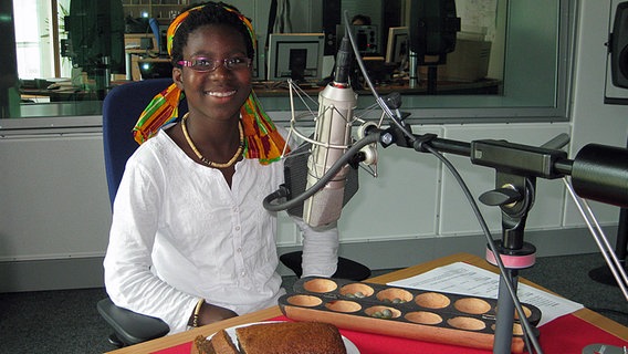 Mariama ist zu Gast im Mikado-Studio. Sie hat ein selbstgebackenes Bananenbrot und ein afrikanisches Spielzeug mitgebracht. © NDR Foto: Katharina Mahrenholtz