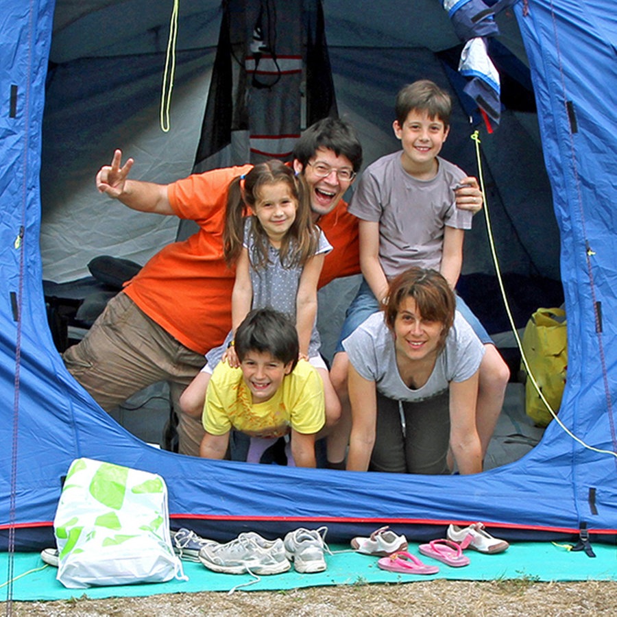 Eine junge Familie sitzt am Eingang in einem Zelt. © Fotolia Foto: ChiccoDodiFC