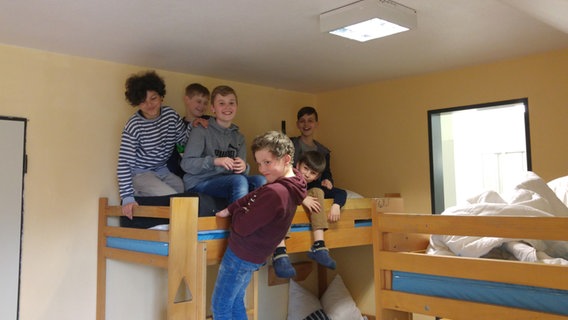 Sechs Jungen sitzen in einem Hochbett. © NDR Foto: Jantje Fischhold
