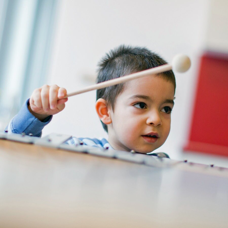 Ein Kind musiziertt auf einem Xylophon. © dpa Foto: Rolf Vennenbernd