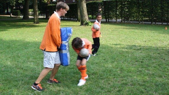 Rugby-Trainer Michael von den Eimsbütteler Koalas des ETV Hamburg lasst einen Spieler an der "Tackle Bag" üben. © NDR Foto: Beke Schulmann