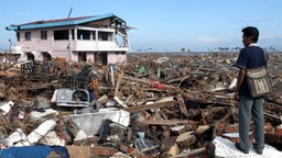 Ein Indonesier zwischen den Trümmern seines von dem Tsunami verwüsteten Hauses. (09.01.2005) © dpa - Bildfunk Foto: Andy Rain