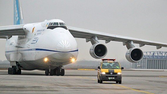 Eine große Antonow-Transportmaschine auf dem Rollfeld. Davor eine Fahrzeug des Airports, das die Maschine zum Abstellplatz leitet. Eine große Antonow-Transportmaschine auf dem Rollfeld. Davor eine Fahrzeug des Airports, das die Maschine zum Abstellplatz leitet. © Bundeswehr/Mandt Foto: Michael Mandt