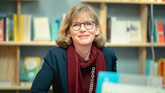 Ina Schmidt sitzt lächelnd am Schreibtisch. © Dr. Ina Schmidt 