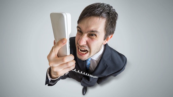 Mann starrt wütend einen Telefonhörer an © Fotolia.com Foto: vchalup