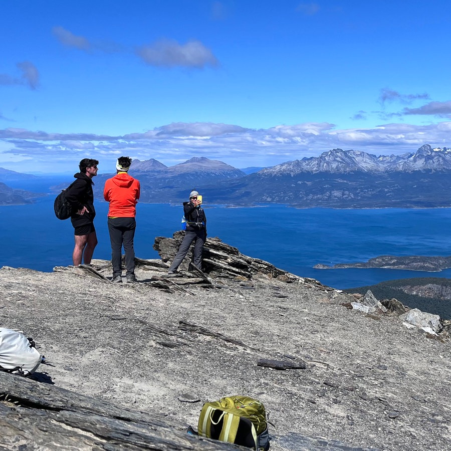 Zwei Menschen in Argentinien laufen auf einem Berg, dahinter ist der blaue Himmel zu erkennen © NDR Foto: Max-Marian Unger