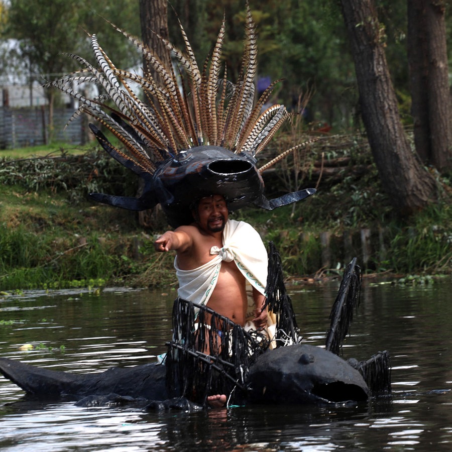 Ein Mann mit vielen Federn als Kopfschmuck sitzt in einem Boot in Form einer Amphibie: ein Axolotl in Mexiko ©  Luis Barron/Eyepix Group/ABACAPRESS.COM Foto:  Luis Barron