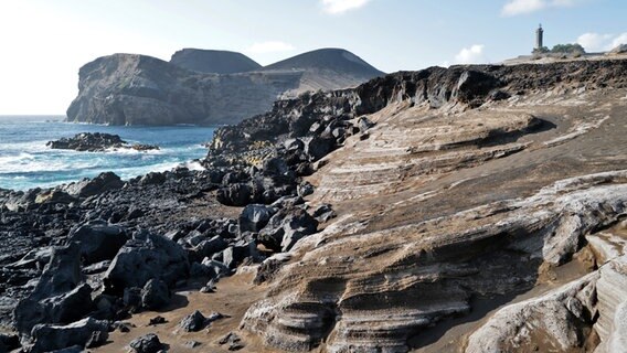 eine Vulkanlandschaft an der Küste von Faial, eine Insel der Azoren mit Leuchtturm © NDR Foto: Oliver Neuroth