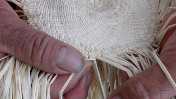 Hände flechten das Stroh für einen Panama-Hut © NDR Foto: Lissette Molina de Becker